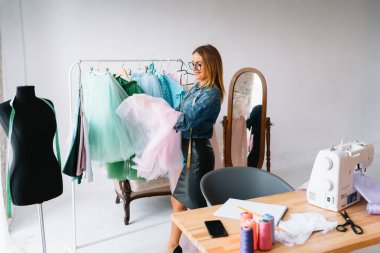 Çekici bayan moda tasarımcısı atölyesinde çalışıyor. Yeni kıyafet koleksiyonu yapan şık bir kadın..