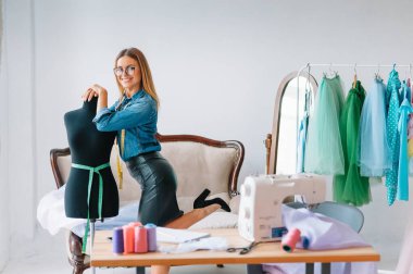 Yeni koleksiyon üzerinde çalışıyorum. Yeni düzen. Kadın moda tasarımcısı atölyedeki yeni kıyafetler üzerinde çalışıyor..