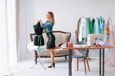 Herhangi bir hata yapamam. Kadın moda tasarımcısı atölyedeki yeni kıyafetler üzerinde çalışıyor..