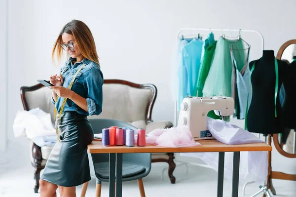 Can't make any mistake. Female fashion designer works on the new clothes in the workshop.