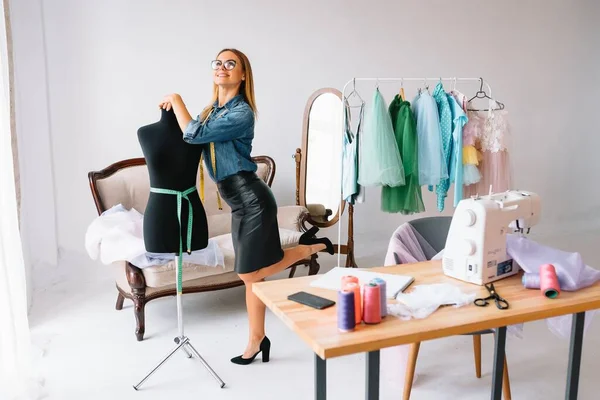 Can't make any mistake. Female fashion designer works on the new clothes in the workshop.