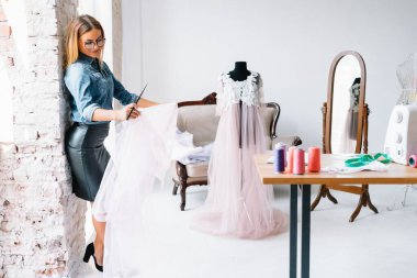 Yeni koleksiyon üzerinde çalışıyorum. Yeni düzen. Kadın moda tasarımcısı atölyedeki yeni kıyafetler üzerinde çalışıyor..