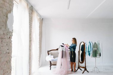 Mutlu genç moda deisgner stüdyosunda. terzilik konsepti