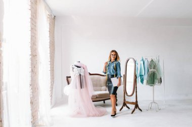 Yeni koleksiyon üzerinde çalışıyorum. Yeni düzen. Kadın moda tasarımcısı atölyedeki yeni kıyafetler üzerinde çalışıyor..