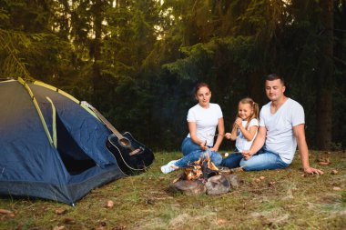 Aile kampı ve kamp ateşinde yemek yapmak.