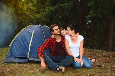 Kamp tatilleri. Üç kişilik bir aile kamp yapıyor ve eğleniyor..