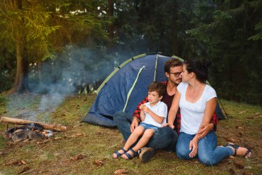 Aile tatili dağ kampında. Âşık aile, mutlu, rahatlatıcı doğa geçmişi. Aşk konsepti. Kamp tatili. Dağlarda kamp yapmak. Aile seyahati. Yaz tatili. Aile kamp çadırının yanında..