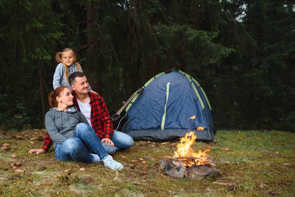 family vacation in the mountains camp. Family in love happy relaxing nature background. Love concept. Camping vacation. Camping in mountains. Family travel. Summer vacation. Family near camping tent.
