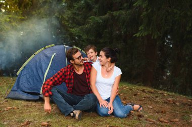 Kamp tatilleri. Üç kişilik bir aile kamp yapıyor ve eğleniyor..
