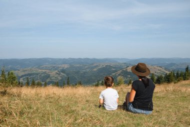 Genç anne ve küçük oğlu seyahat ediyorlar. Aile gezisi dağlarda. Ulusal Park. Çocuklarla yürüyüş. Aktif yaz tatili. Fisheye merceği
