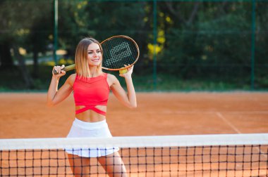 Gülümseyen genç kız tenis oynuyor.