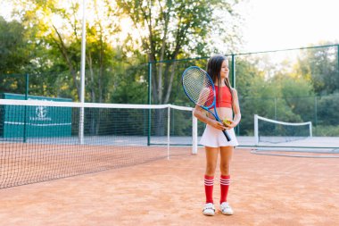 Sıcak ve güneşli bir yaz gününde dışarıda badminton oynayan tatlı küçük kız.