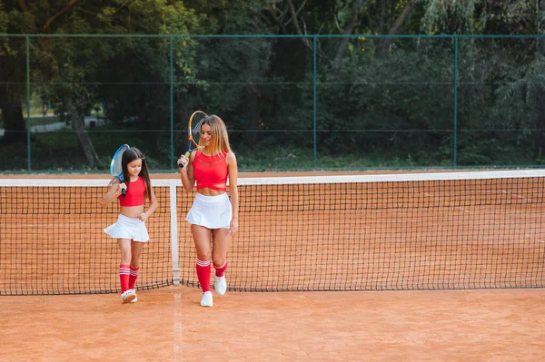 Aantrekkelijke Jonge Moeder Helpt Haar Dochter Tennissen — Stockfoto