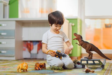 Evdeki bir sürü oyuncağın etrafında dinozorlarla oynayan sevimli bir bebek. Evde kal..