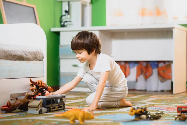 おもちゃの車をプレイマットで遊んでいる男の子 カラフルな教育車両やカーペットの上で輸送おもちゃを持つ若い子供 シティストリートマップラグ 駐車場に子供の運転車 家庭や保育園の子供たち — ストック写真