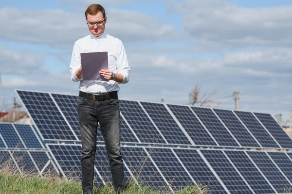 solar panels and blue sky.Man standing near solar panels. Solar panel produces green, environmentally friendly energy from the sun.