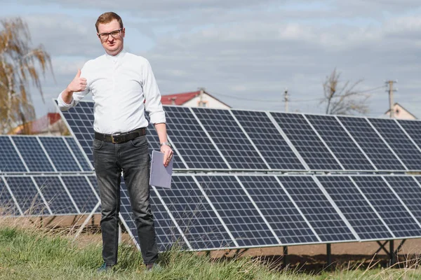 solar panels and blue sky.Man standing near solar panels. Solar panel produces green, environmentally friendly energy from the sun.