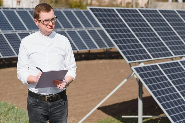 solar panels and blue sky.Man standing near solar panels. Solar panel produces green, environmentally friendly energy from the sun.