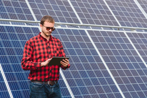 solar panels and blue sky.Man standing near solar panels. Solar panel produces green, environmentally friendly energy from the sun.