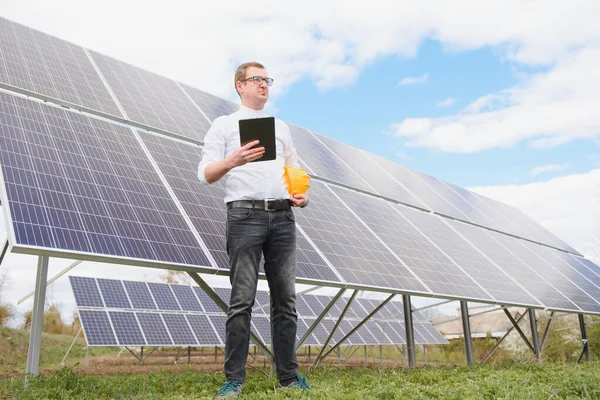 solar panels and blue sky.Man standing near solar panels. Solar panel produces green, environmentally friendly energy from the sun.