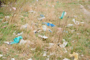 Doğanın ekolojik kirliliği. Plastik torba, bitkilerin arasına dağların arka planına dolanmış. Küresel çevre kirliliği. Geri dönüşüm, plastikten arta kalan toprakları temizlemek..