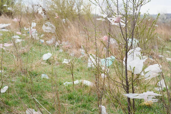 Ecological pollution of nature. Plastic bag tangled in plants against the backdrop of the mountains. Global environmental pollution. Recycling, clearing the land from plastic debris.