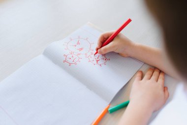 Küçük çocuk koronavirüs çiziyor. Evde kalıp eğlenin.