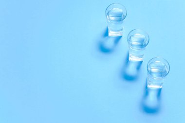 Kağıt üzerinde bir bardak su. Gölgeler çiziyor. Klasik mavi renk. Temiz su kavramı