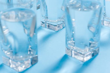 Kağıt üzerinde bir bardak su. Gölgeler çiziyor. Klasik mavi renk. Temiz su kavramı