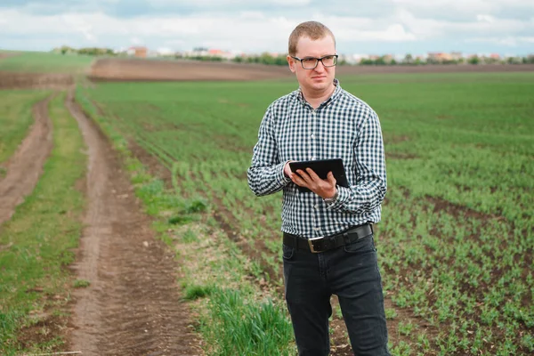 happy farmer in the fields with a laptop computer