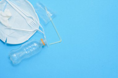 Mavi arka planda beyaz plastik. Plastik kirliliği. Geri dönüşüm plastiği, yeniden kullanılabilir paketler, çöp konsepti. Sıfır atık, ekoloji. Kopyalama,