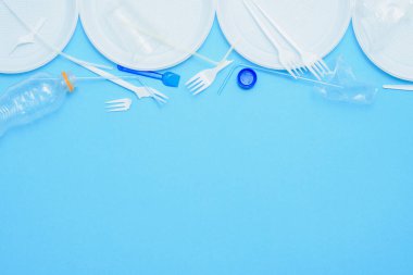 Mavi arka planda beyaz plastik. Plastik kirliliği. Geri dönüşüm plastiği, yeniden kullanılabilir paketler, çöp konsepti. Sıfır atık, ekoloji. Kopyalama,