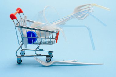 Sosyal çevre sorunu. Gezegenin plastik kirliliği. Mavi arka planda beyaz plastik. Ekolojik felaket. Çubuğun sıralanıp incelenmesi. Çevrede plastik atığı. Eko sorunu