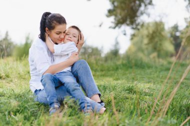 Huysuz anne ve yakışıklı oğul doğada eğleniyor. Mutlu aile kavramı. Aile hayatı olan güzel doğa manzarası. Mutlu bir aile birlikte dinleniyor. Aile yaşamında mutluluk. Anneler Günü.