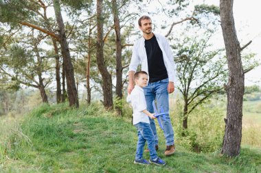 Babanızla iyi eğlenceler. Aile eğlence konsepti. Sakallı bir adam ve tatlı bir oğul. Çocuklar gülümser. Babamla bahar yürüyüşü..