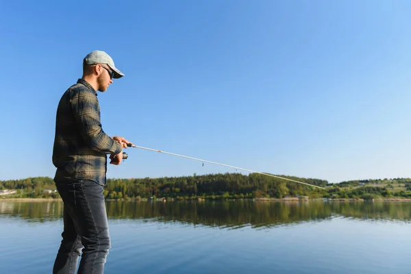 在河里钓鱼一个在河岸上拿着钓竿的渔夫 渔夫钓到一条鱼 酿酒等 农村出逃的概念 关于捕鱼的文章 — 图库照片