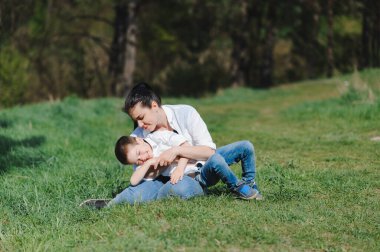 Anne ve oğlunu öp ve kucakla. Anne ve oğlu yaz parkında yürüyor. Aile tatili ve birliktelik. Anneler günün kutlu olsun..