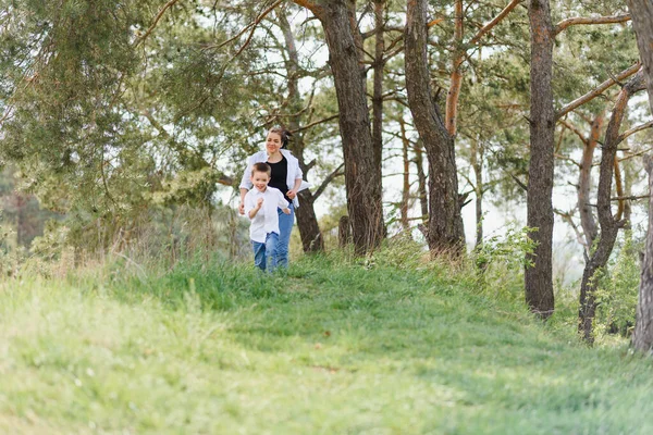 母と息子の幸せな家族 魅力的なお母さん 子供の男の子はのんきな屋外の夏を歩いています 親の女性は子供 春の日と一緒に自然に行きます コピースペース 幸せな家族 — ストック写真