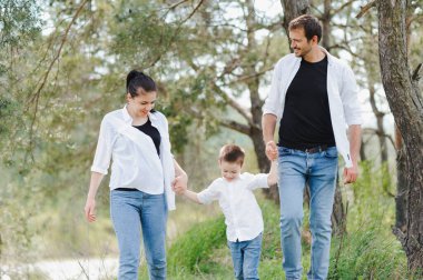 Baba, anne ve küçük oğlu dışarıda birlikte eğleniyorlar. Aile gezisi. Dışarıda mutlu bir aile. Aile, tatil kavramı