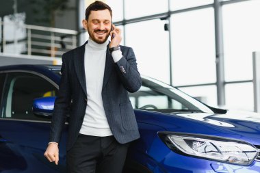 iş, araba satışı, tüketim ve insan konsepti - otomobil fuarı veya kuaför geçmişi üzerinden mutlu adam