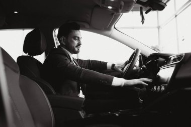 Çekici, zarif, ciddi adam iyi araba kullanıyor.