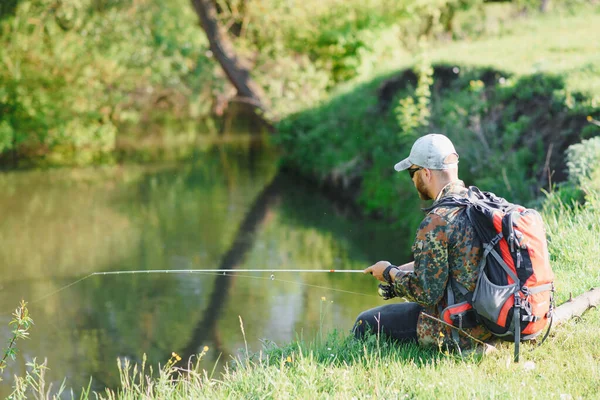 湖畔でのんびりと釣りをする男 釣りのための週末 フィッシャー男性趣味 バイター様 落ち着いて魚を釣りなさい 漁師は大きな魚を待っている川にスピンクロッキー 男フライフィッシング — ストック写真