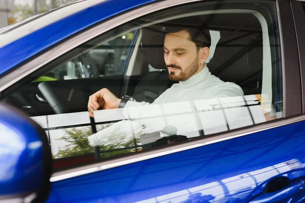 Close-up of man looking at his watch on his hand while sitting in his car he hurrying to a meeting