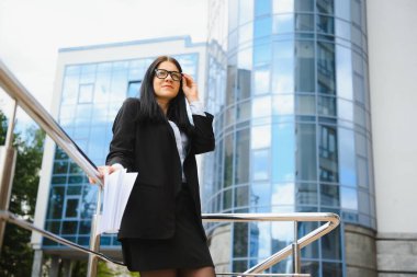 Modern ofisin arka planında güzel bir iş kadını