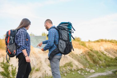 Ulusal Park 'ta yürüyüş yaparken doğa manzarasının tadını çıkaran iki gezgin. Bir çift yürüyüşçü seyahat sırasında haritayı bulmak için bir sonraki yolu planlıyorlar. En üst hedeflere sahip bilgi grafikleri resimleme haritası