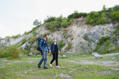 Dağda yürüyüş yapan mutlu genç çift.