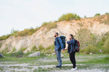 Güneşli bir günde yüksek bir tepenin tepesinde duran iki güzel gezgin, yaz tatilini beklerken erkek ve dişi yürüyüşçüler dağlarda birlikte yürüyorlar.