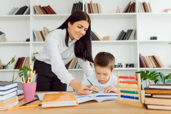 tutor deals with the preschooler with a laptop, a real home interior, the concept of childhood and learning
