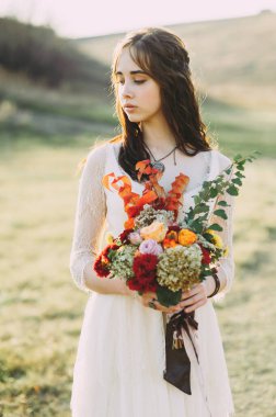 Düğün buketini tutan gelin, sulu çiçeklerle, yakın plan