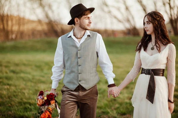 Novio con estilo en un sombrero y una novia caminar en la naturaleza —  Fotos de Stock